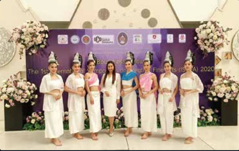 คณะนักแสดงในชุดไทยสีขาวถ่ายภาพร่วมกันบนเวทีงานวัฒนธรรมนานาชาติ