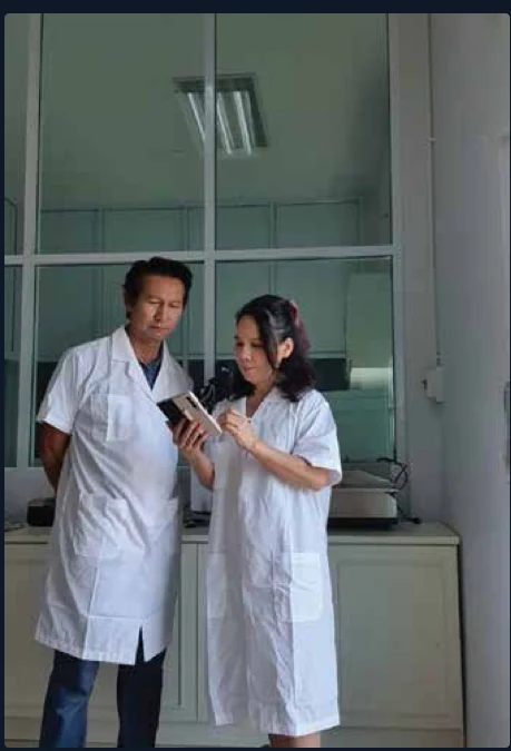 ทีมควบคุมคุณภาพในชุดกาวน์ตรวจสอบผลิตภัณฑ์ภายในห้องปฏิบัติการของโรงงาน